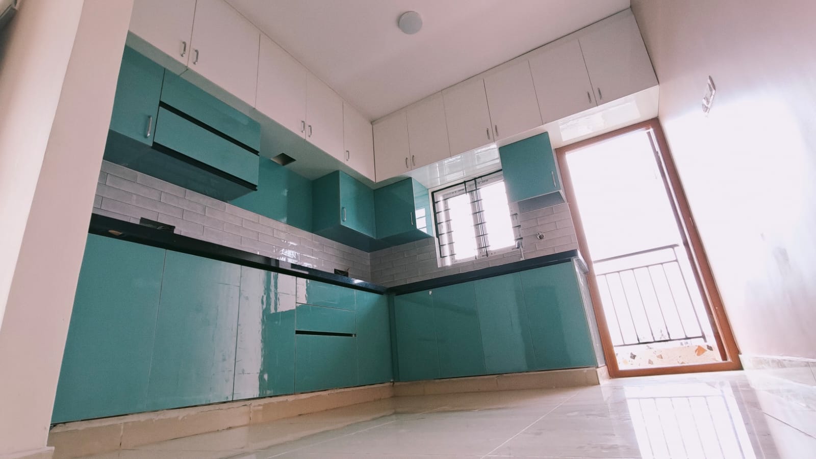 Kiran project kitchen with green cabinetry and an L-shaped worktop